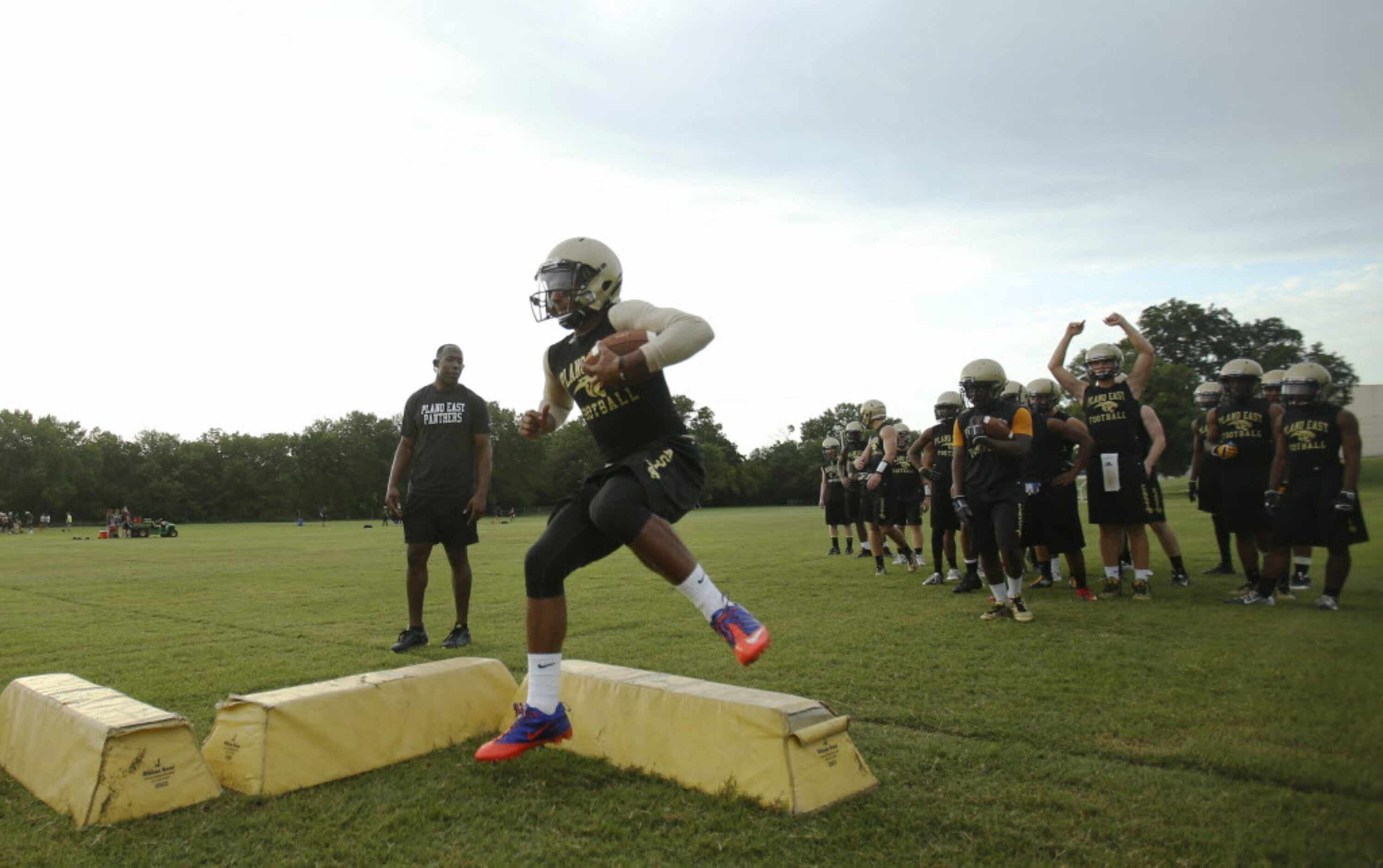 Plano East's quarterback Miles Thompson runs through a drill during the first day of...