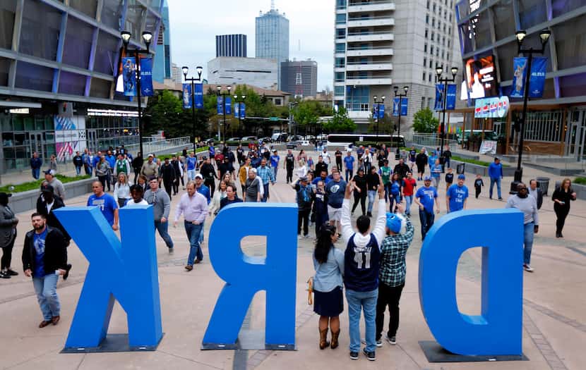 Dallas Mavericks fans pose for photos in the DIRK sign outside American Airlines Center in...