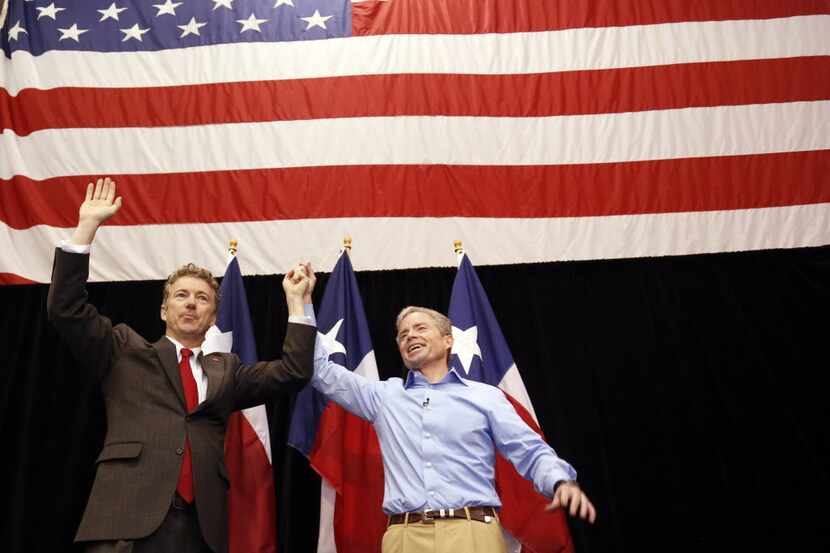  U.S. Sen. Rand Paul (R-Ken.) and Texas Senate candidate Don Huffines hold hands during...