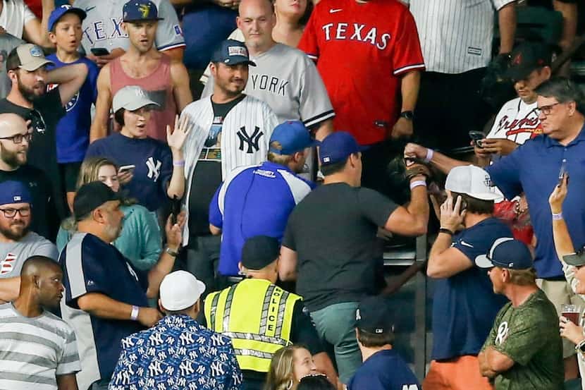 The Texas Rangers fan, (center blue hat) who caught New York Yankees’ outfielder Aaron...