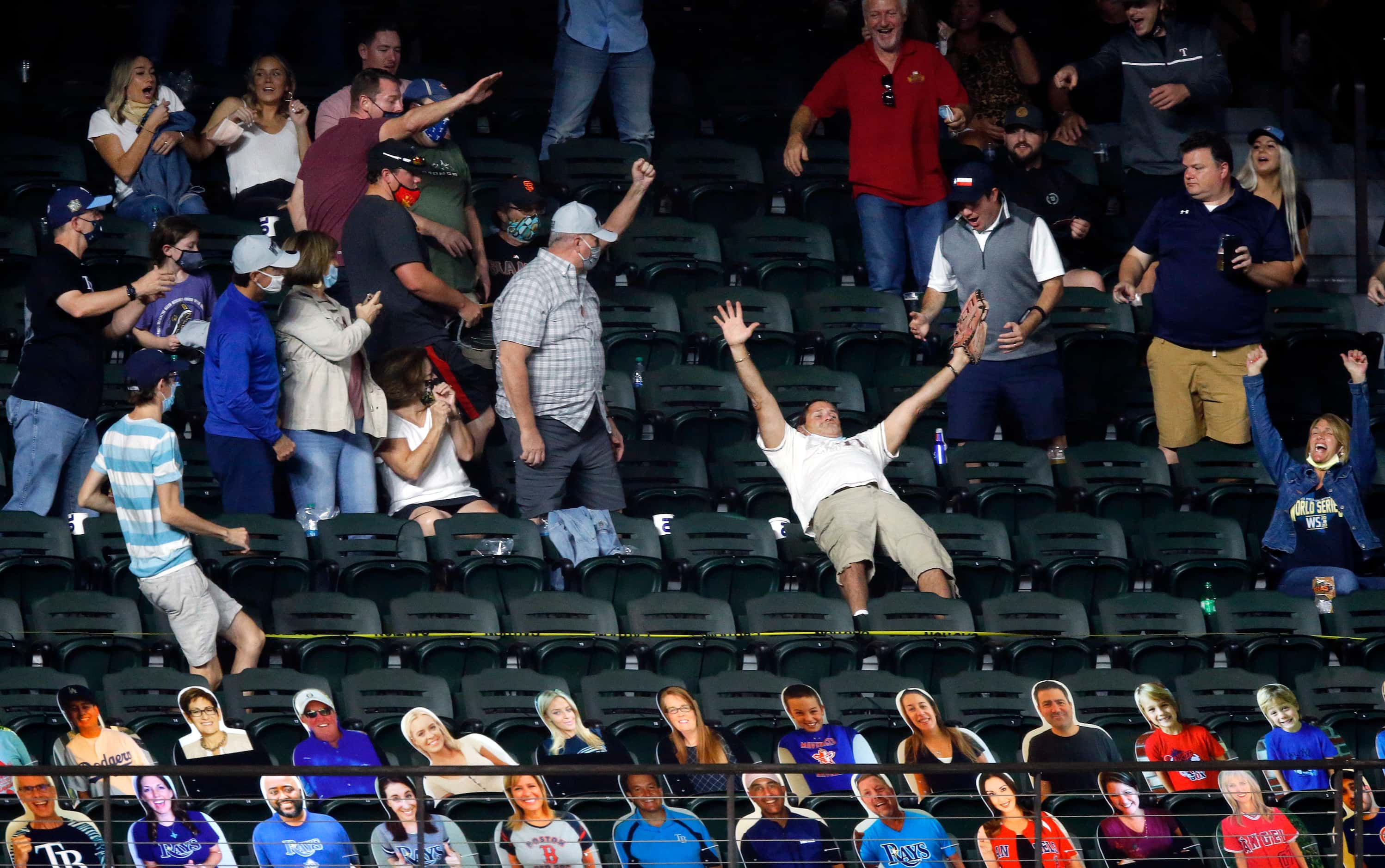 A fan (arms extended) in left field catches Los Angeles Dodgers designated hitter Will...
