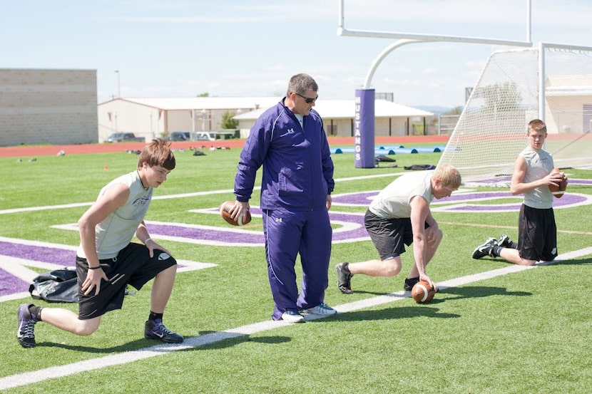 Coach Todd Dodge works out with his quarterbacks at Marble Falls High School on March 21,...