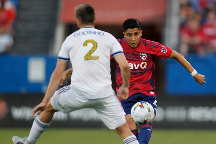 FC Dallas defender Marco Farfan (4) eyes the defense of Vancouver's Marcus Godinho (2) as he...