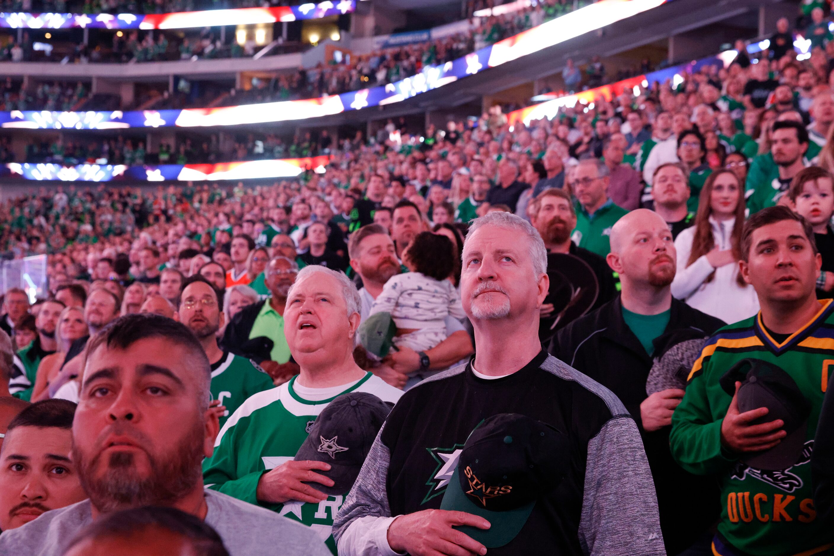 Dallas Stars fans stand for the National Anthem ahead of an an NHL hockey game against...