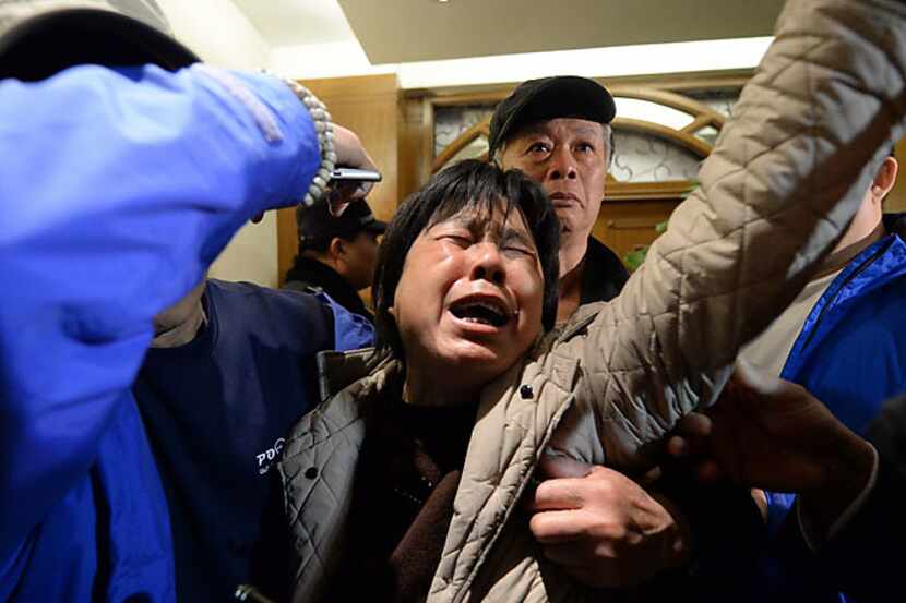 A relative of passengers on Malaysia Airlines flight MH370 cries Monday at a hotel in...