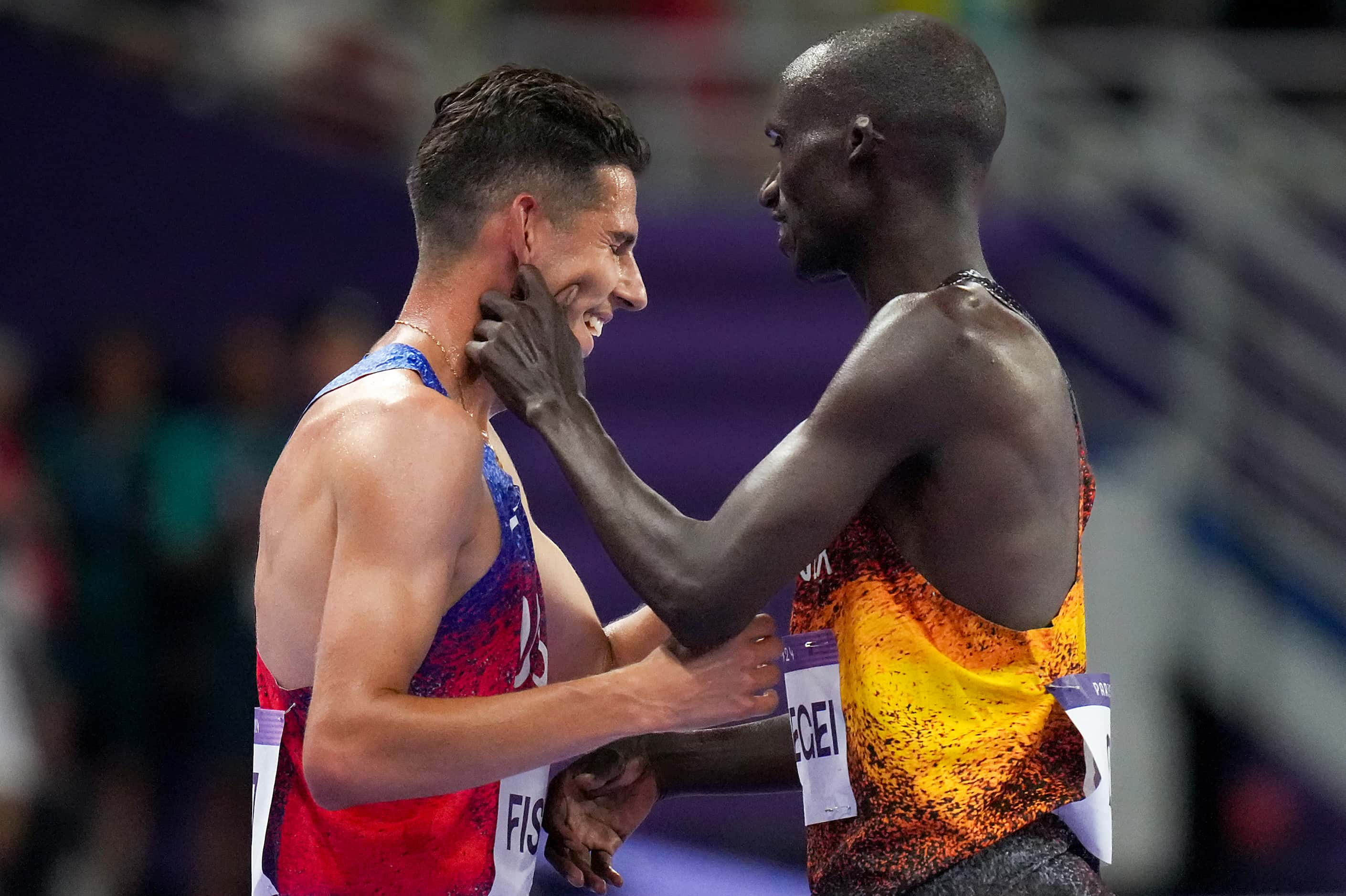 Bronze medalist Grant Fisher of the United States gets a pinch on the cheek from gold...