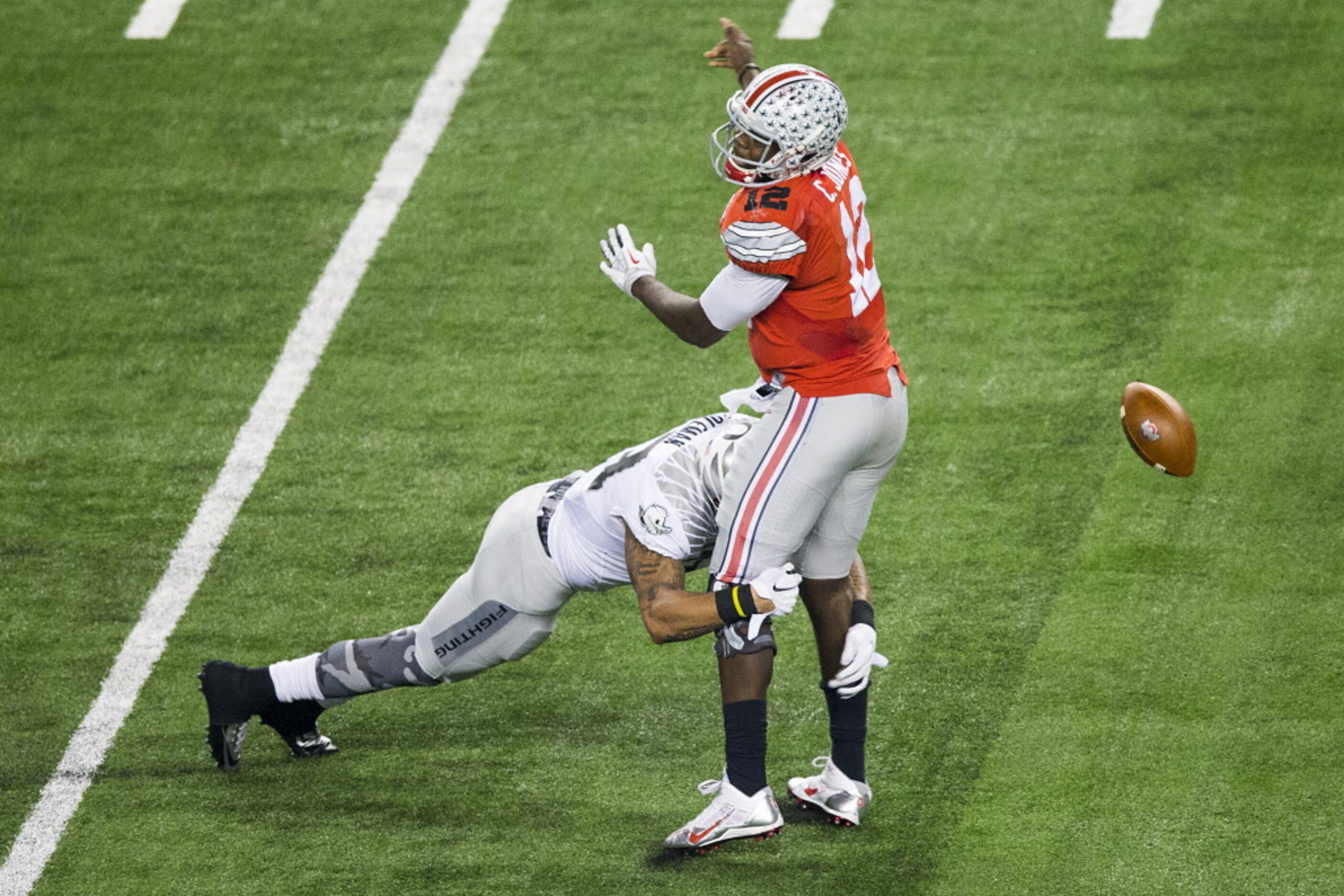 Ohio State Buckeyes quarterback Cardale Jones (12) fumbles as he is hit by Oregon Ducks...