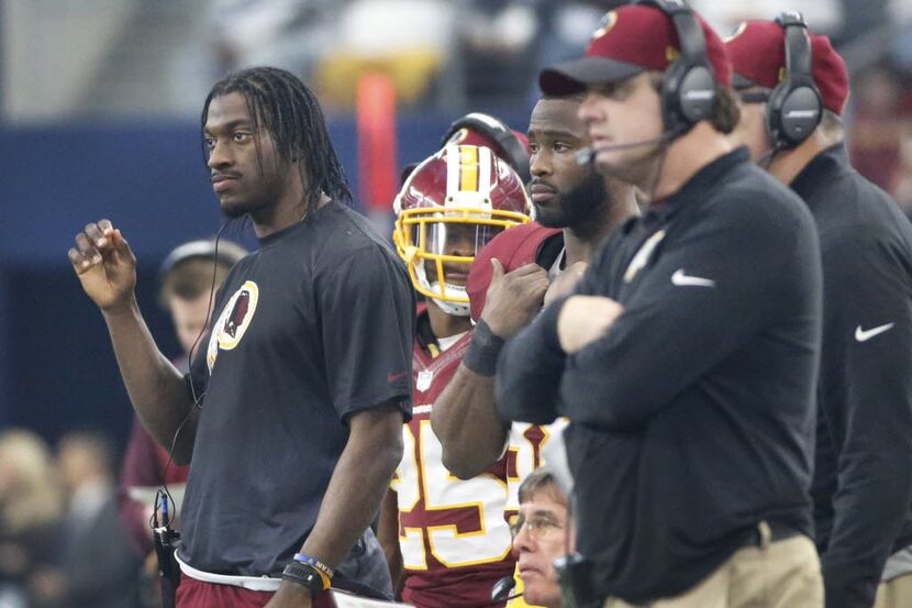 Washington quarterback Robert Griffin III watches the game from the sidelines during the...