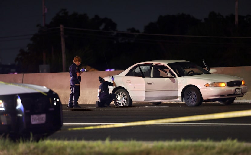 Officers examine Corey Cobb-Bey's white Buick sedan in Lewisville on Aug 30, 2024.