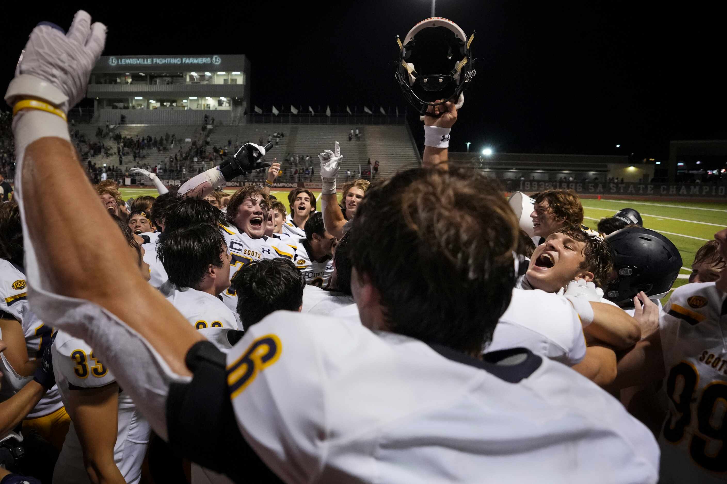 Highland Park players celebrate after a victory over Lewisville in a high school football...