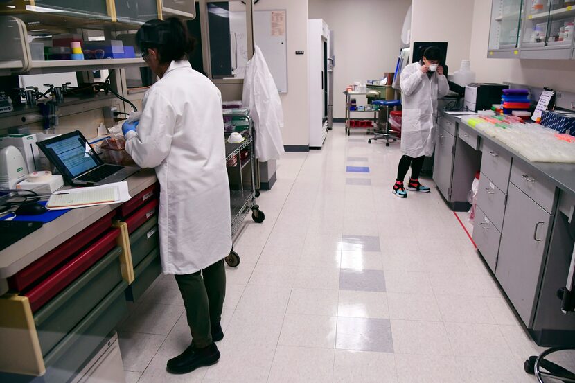 Esparanza Vargas (left) and Ralen Johnson run coronavirus tests at the Colorado Department...