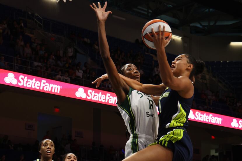 Dallas Wings forward Satou Sabally (0) drives the lane and shoots against the defense of...