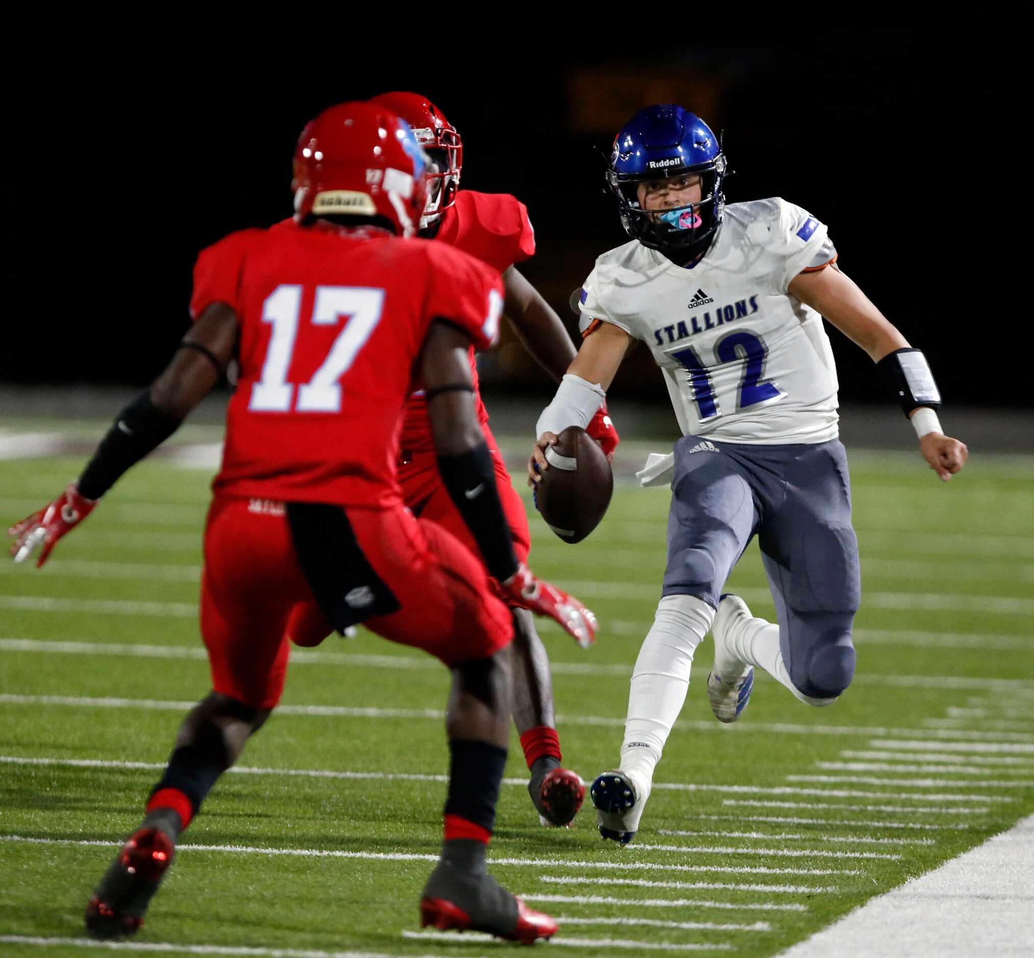 North Mesquite QB Liam Thornton (12) scrambles out of bounds during the first half of a high...