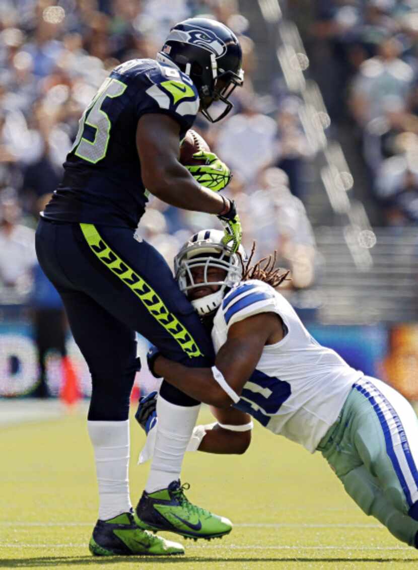 Dallas Cowboys defensive back Danny McCray (40) tries to pull down Seattle Seahawks tight...