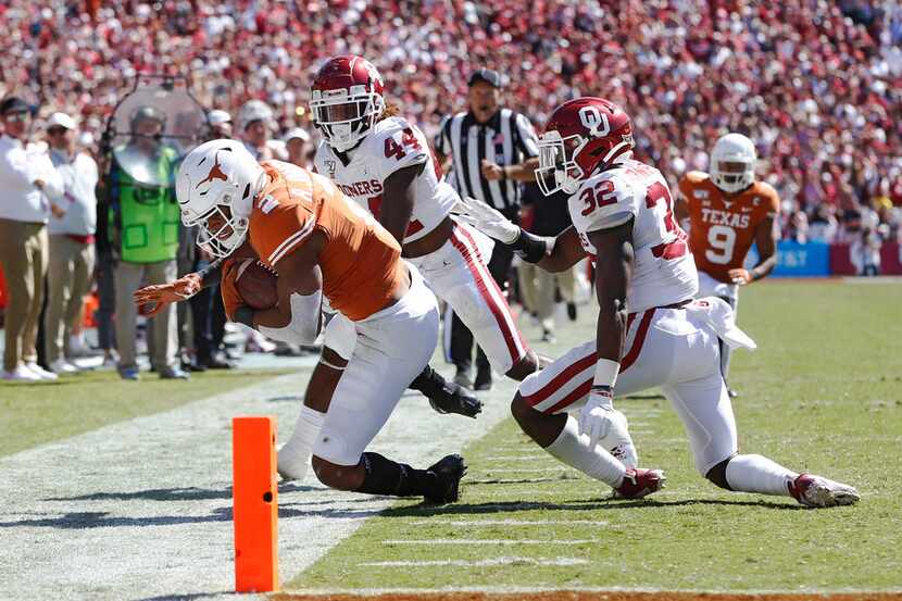 FILE - Texas running back Roschon Johnson (2) is pushed out of bounds by Oklahoma defensive...