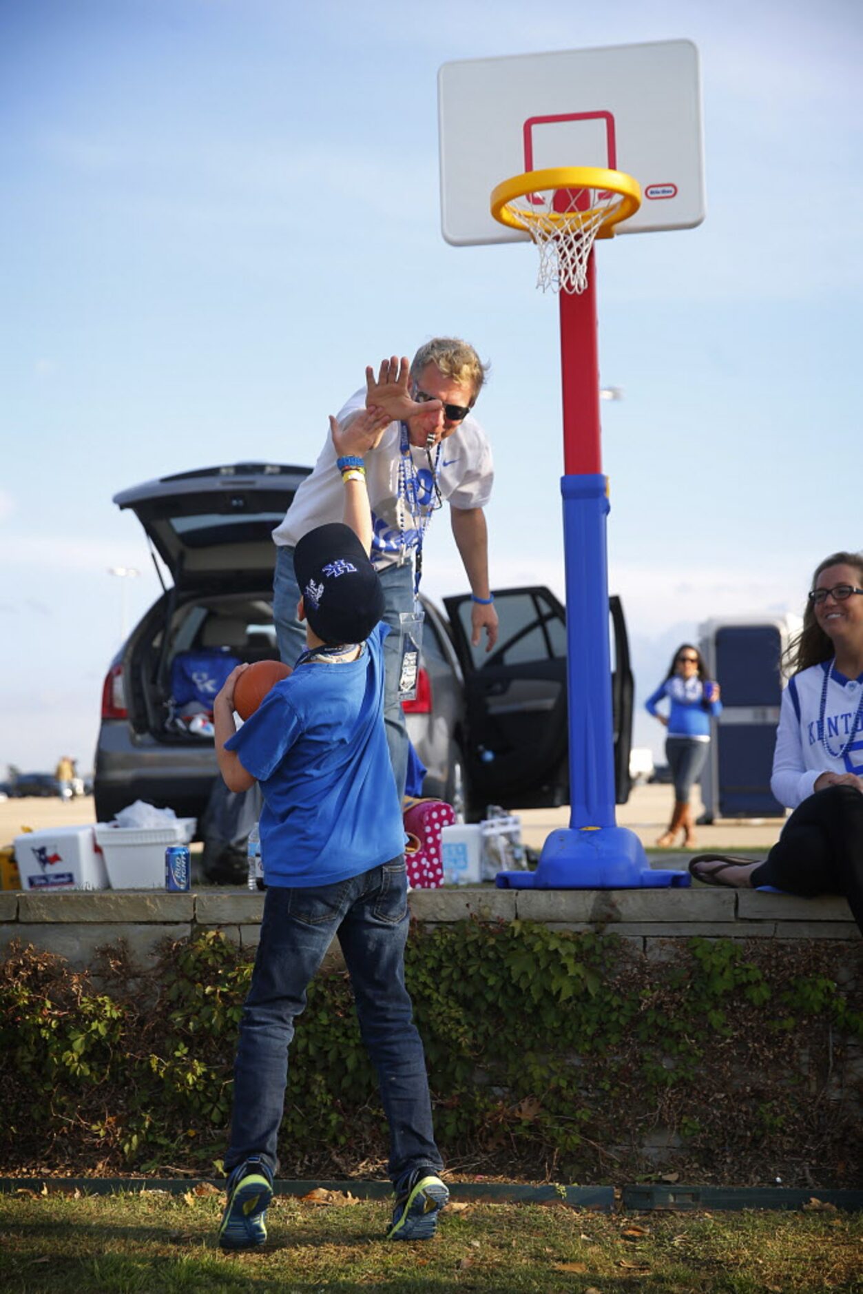 Basketball fan Tim Clark of Louiville, KY high fives 10 hr-old Jake Craft of Tulsa, OK after...