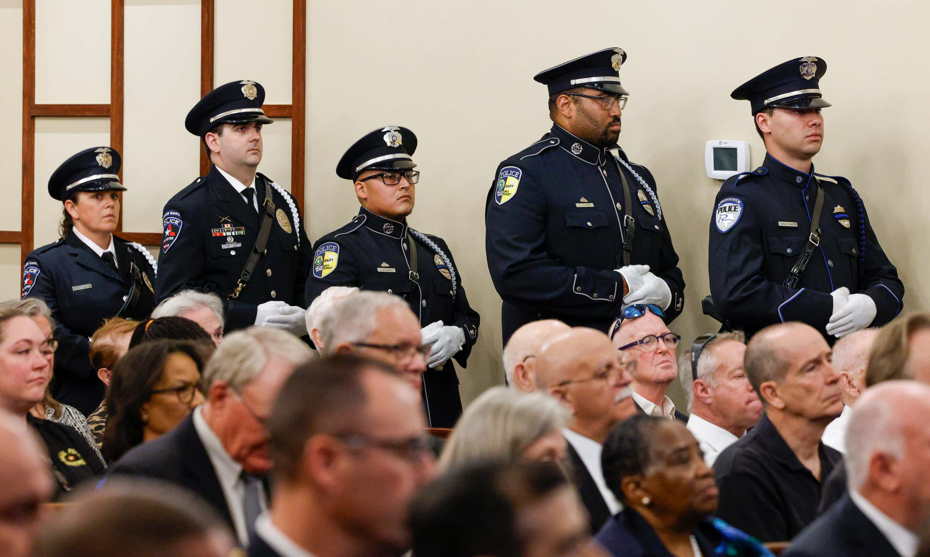 Police honor guard officers from DART, Richardson and Arlington stand during a funeral...