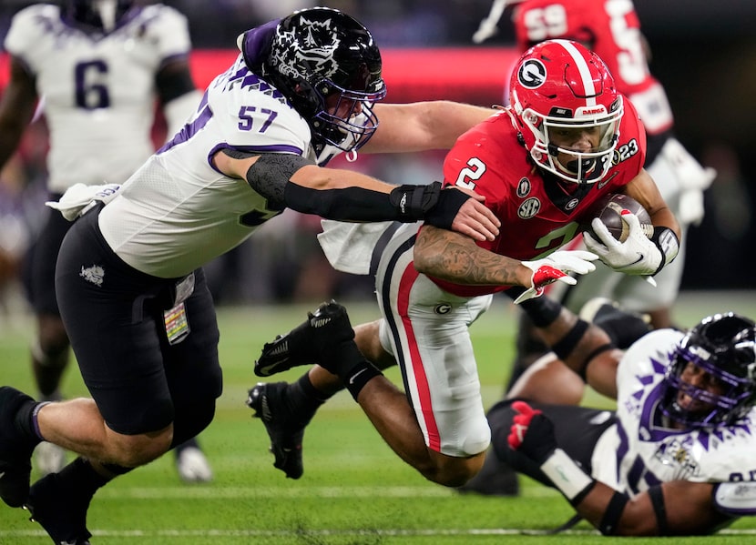 FILE - TCU linebacker Johnny Hodges (57) pressures Georgia running back Kendall Milton (2)...