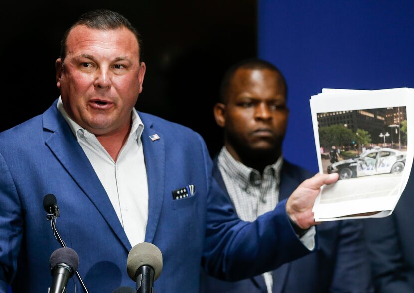 Dallas Police Association Vice President Frederick Frazier shows a photo of a destructed...