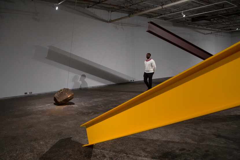 Visitor Olajide Asekun checks out artist Jose Davila's "Directional Energies" exhibition at...