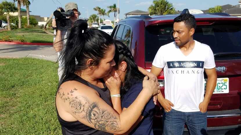 Reina, 40, of El Salvador, with family friend Carlo Mauricio Rodriguez, hugs her 17-year-old...