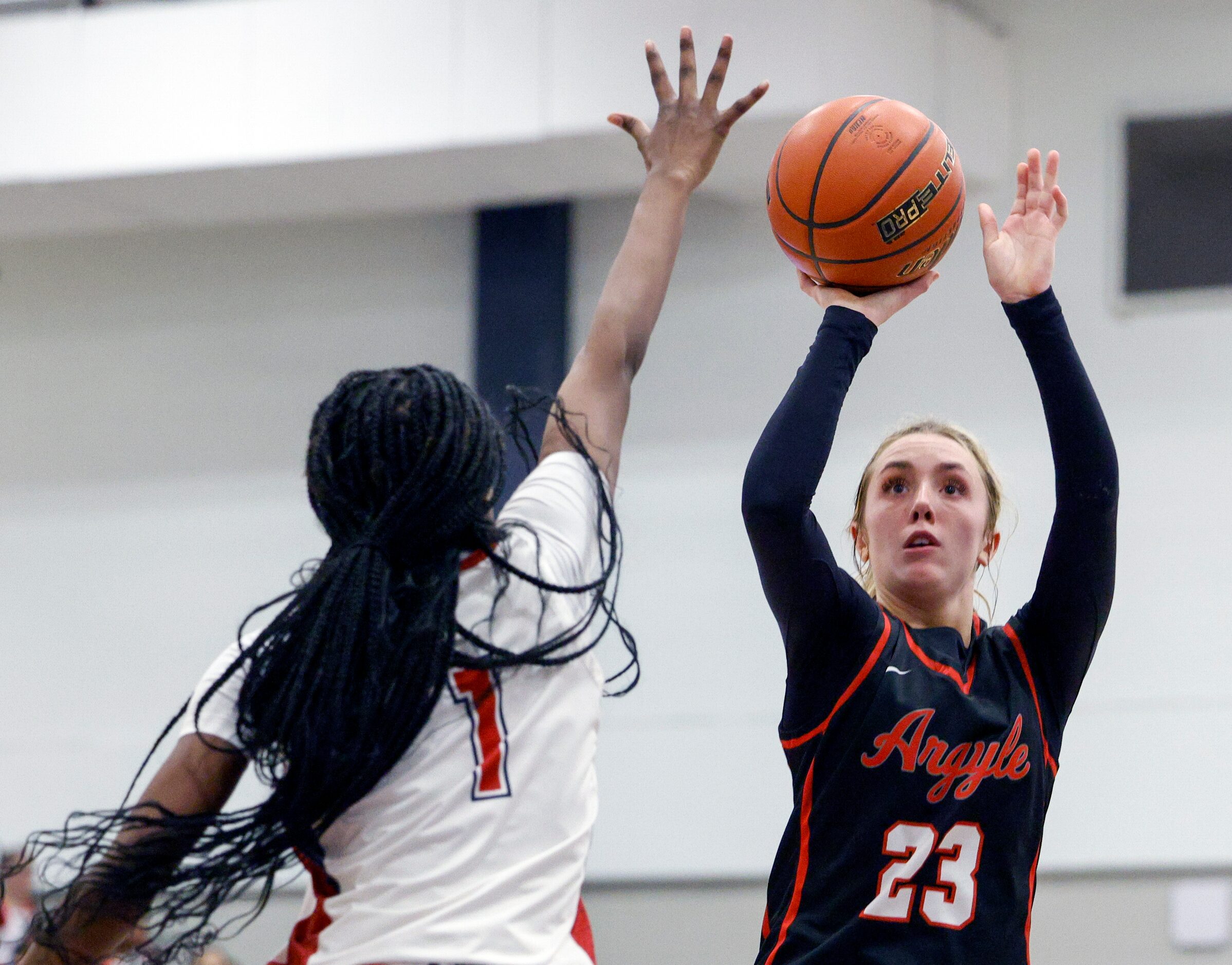 Argyle guard Kennedy Hafer (23) shoots over Denton Ryan guard Daisha Johnson (1) during the...