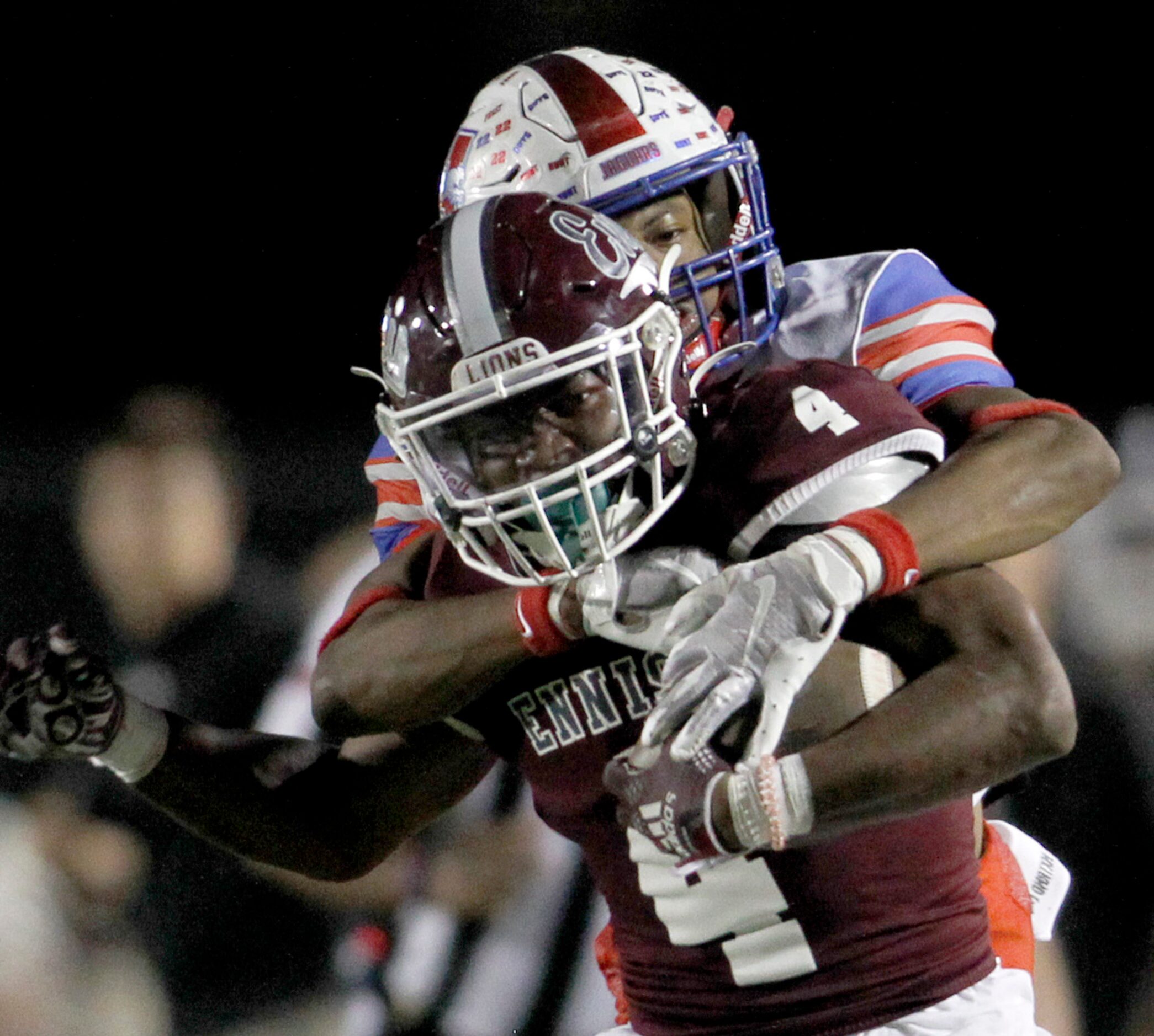 Ennis running back Jeremy Brown, Jr. (4), foreground, rushes for a first down before tackled...