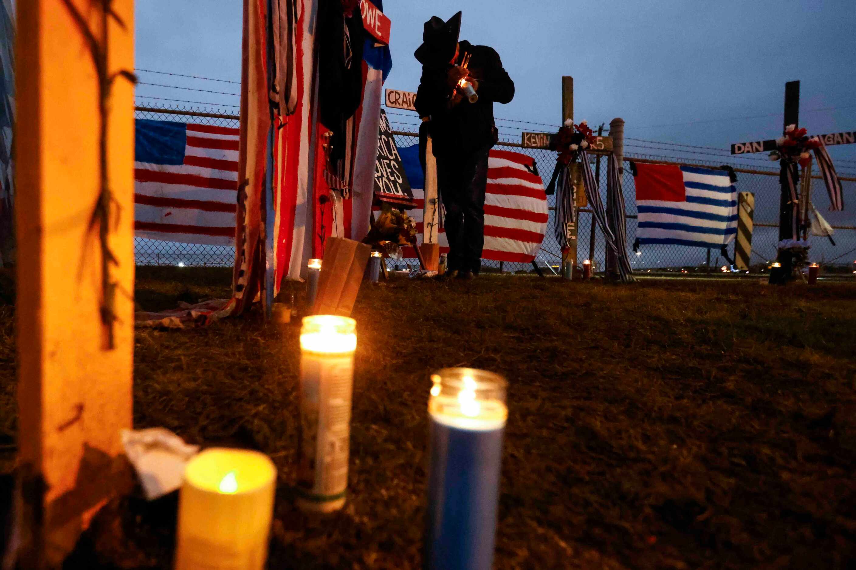 Artist Roberto Márquez lights up a candle intended to put on one of the six painted crosses...