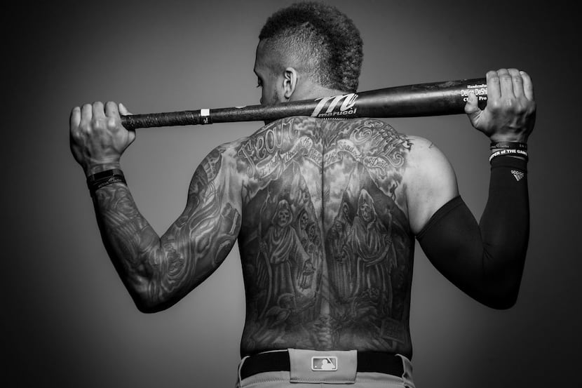 Rangers outfielder Delino DeShields poses for a photo displaying his back tattoo on Monday,...