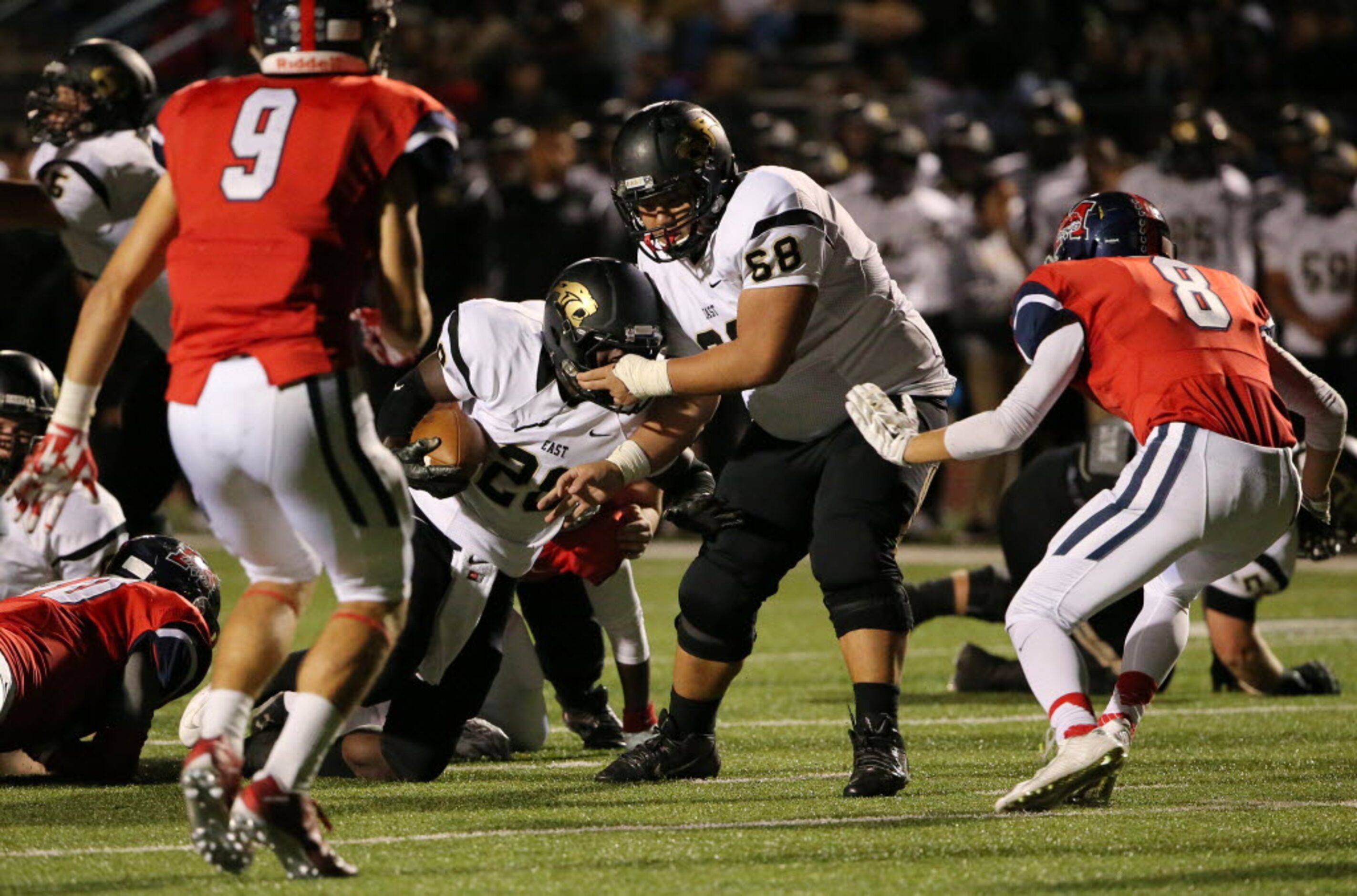 Plano East offensive lineman Cole Moore (68) pulls on the facemark of teammate running back...