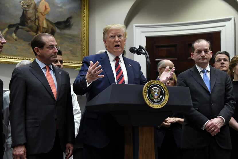 President Donald Trump, flanked by Health and Human Services Secretary Alex Azar (left) and...