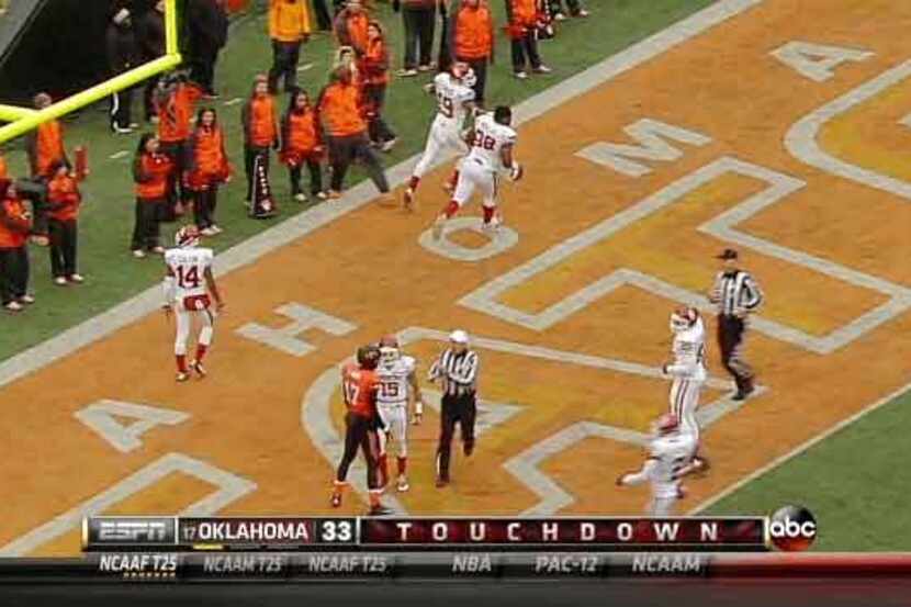 In this frame from the ESPN telecast, an Oklahoma State cheerleader extends a foot in a...