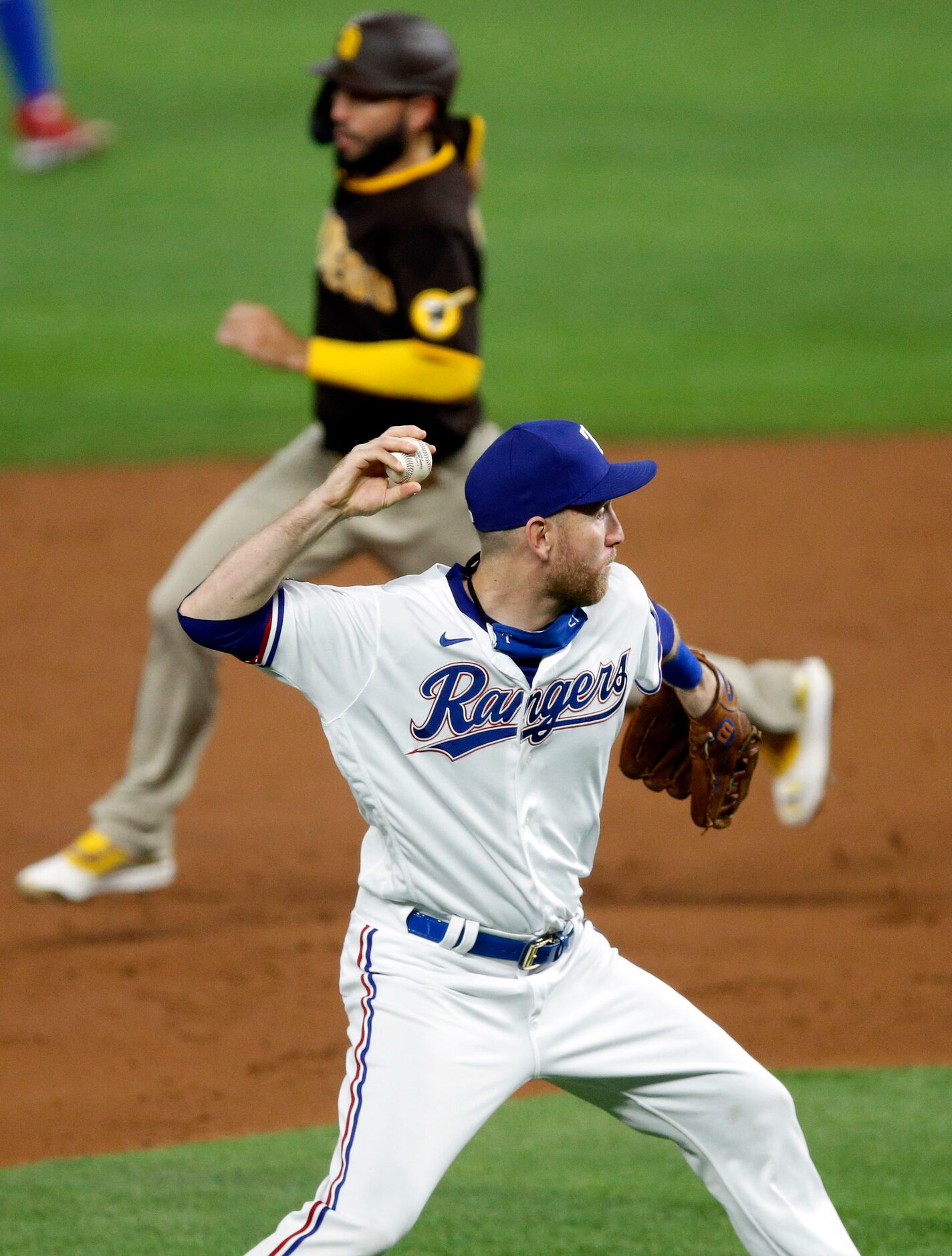 Texas Rangers third baseman Todd Frazier (21) bare hands a batted ball and throws to first...