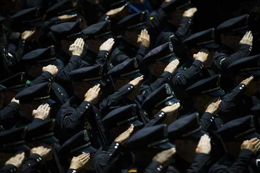Law enforcement officers saluted as the casket carrying Dallas police Sr. Cpl. Lorne Ahrens...