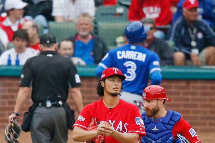 Texas Rangers starting pitcher Yu Darvish (11) talks with catcher Jonathan Lucroy (25) after...