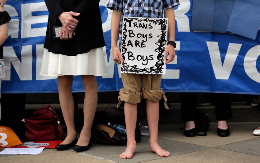 Max Briggle held a sign as he showed solidarity with other transgender Texans during a rally...