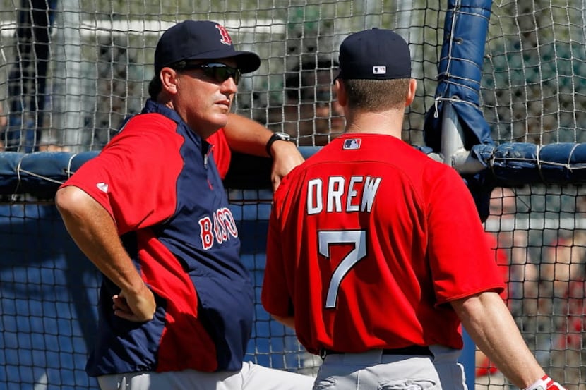 Hitting coach Dave Magadan #29 (L) talks with outfielder J.D. Drew #7 of the Boston Red Sox...