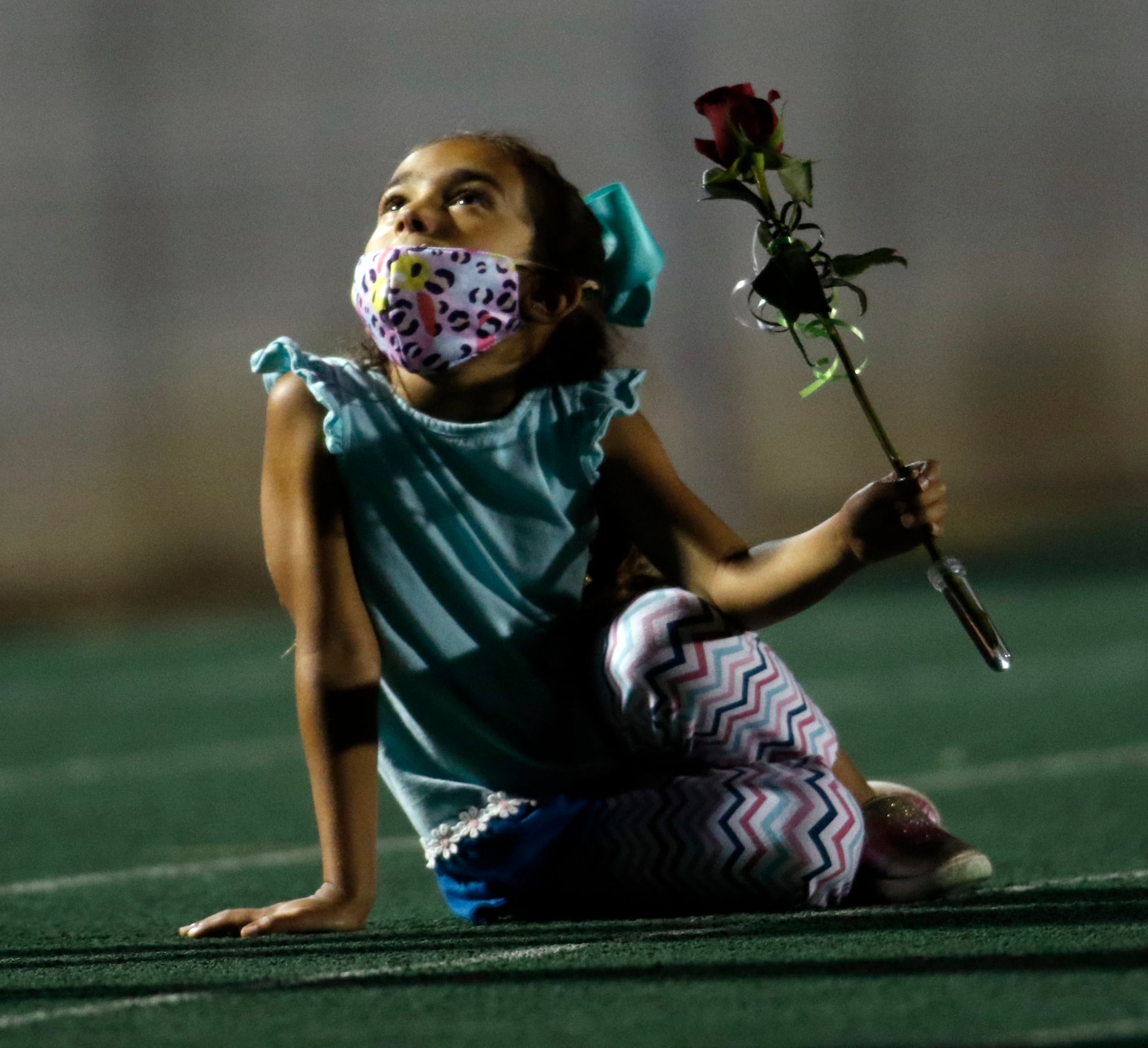 Abby Brooks, 5, looks upward toward her parents just before Kennedale seniors were honored...