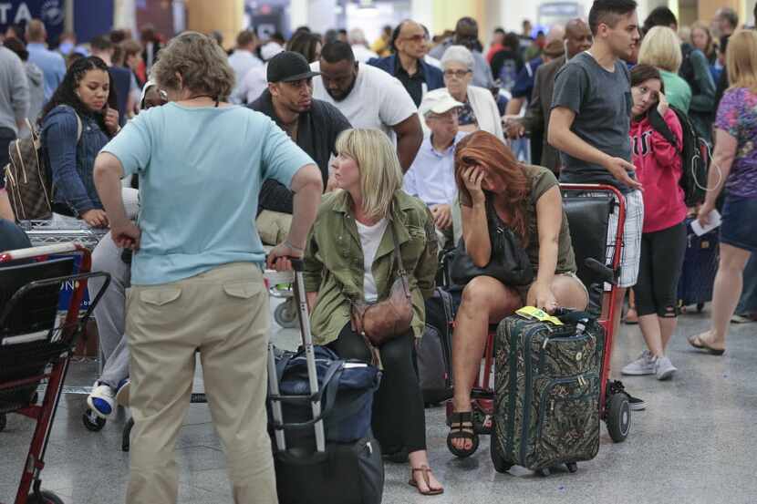 Stranded passengers wait at Hartsfield-Jackson International Airport in Atlanta, Ga., after...