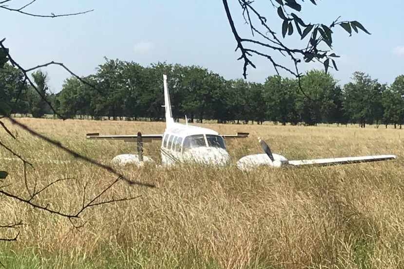 A plane lies in a field after it made an emergency landing in McKinney on Saturday...