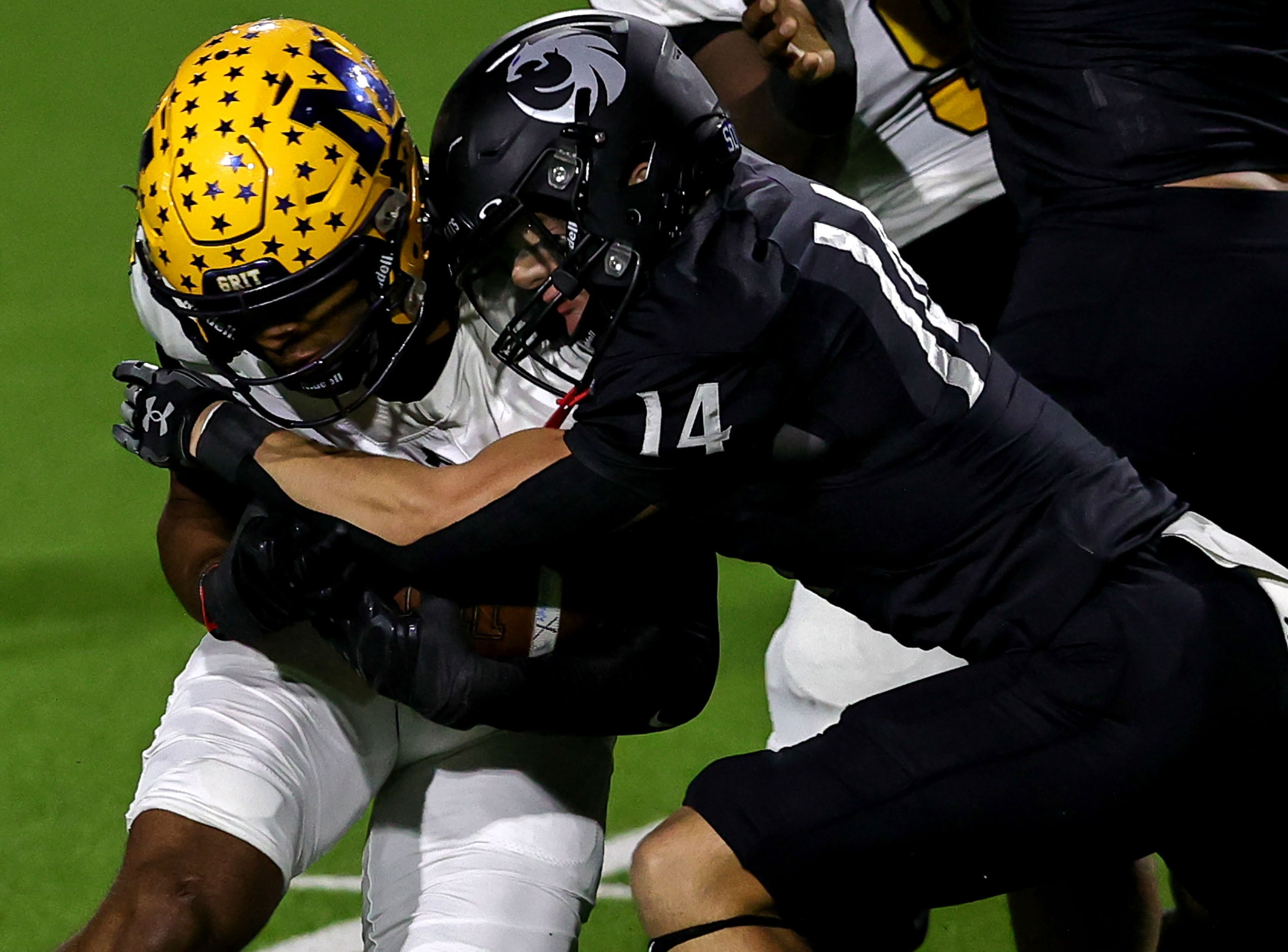 McKinney running back Riley Pettijohn (L) is stopped for a short gain by Denton Guyer...