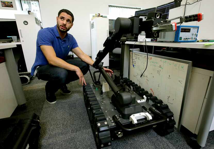 Software engineer Nicholas Otero talks to a colleague about features on a Centaur robot at...
