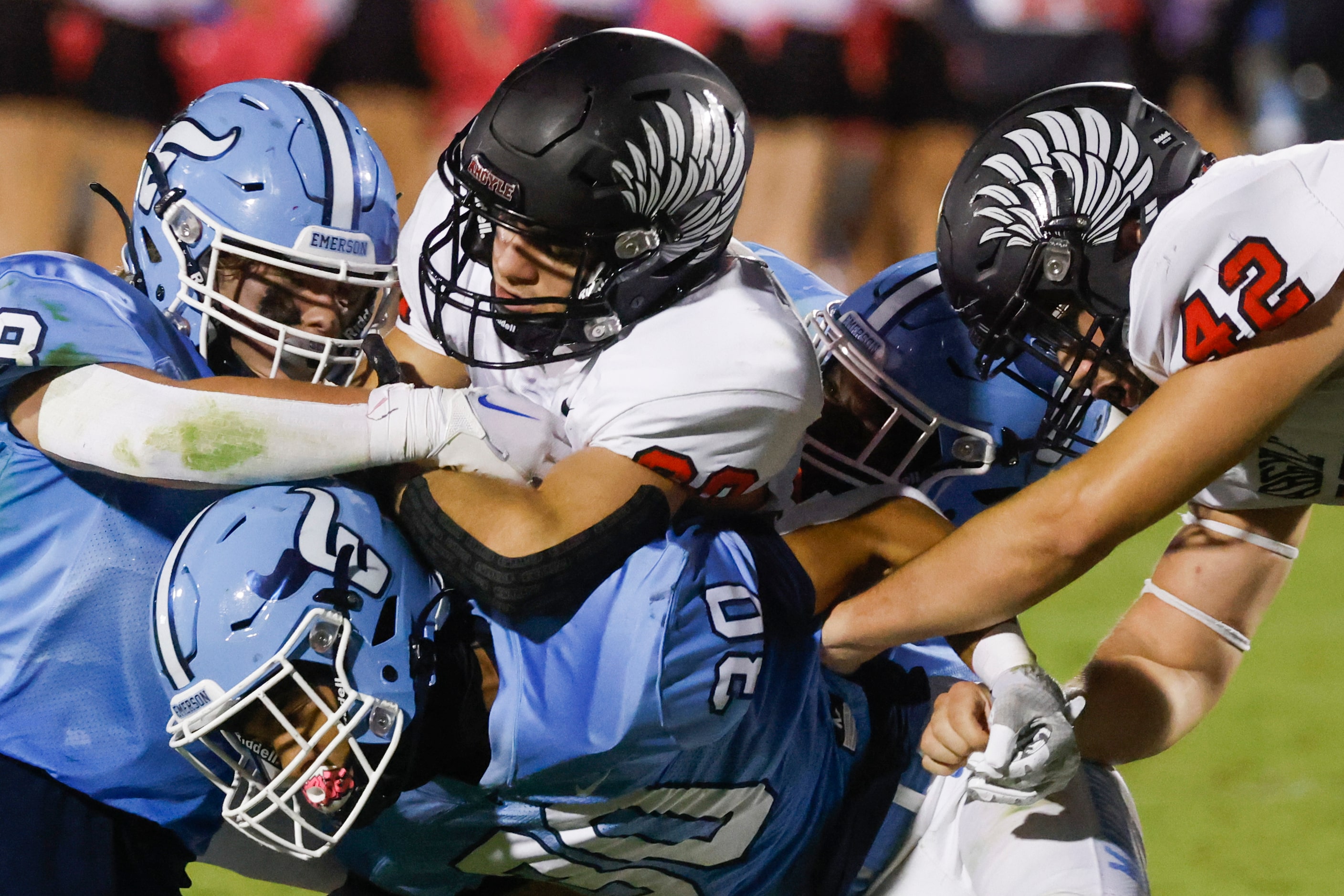 Argyle’s Luke Lane (26), center, gets tackled by Cade Fortner (8), left, Tyson Cannon (30),...