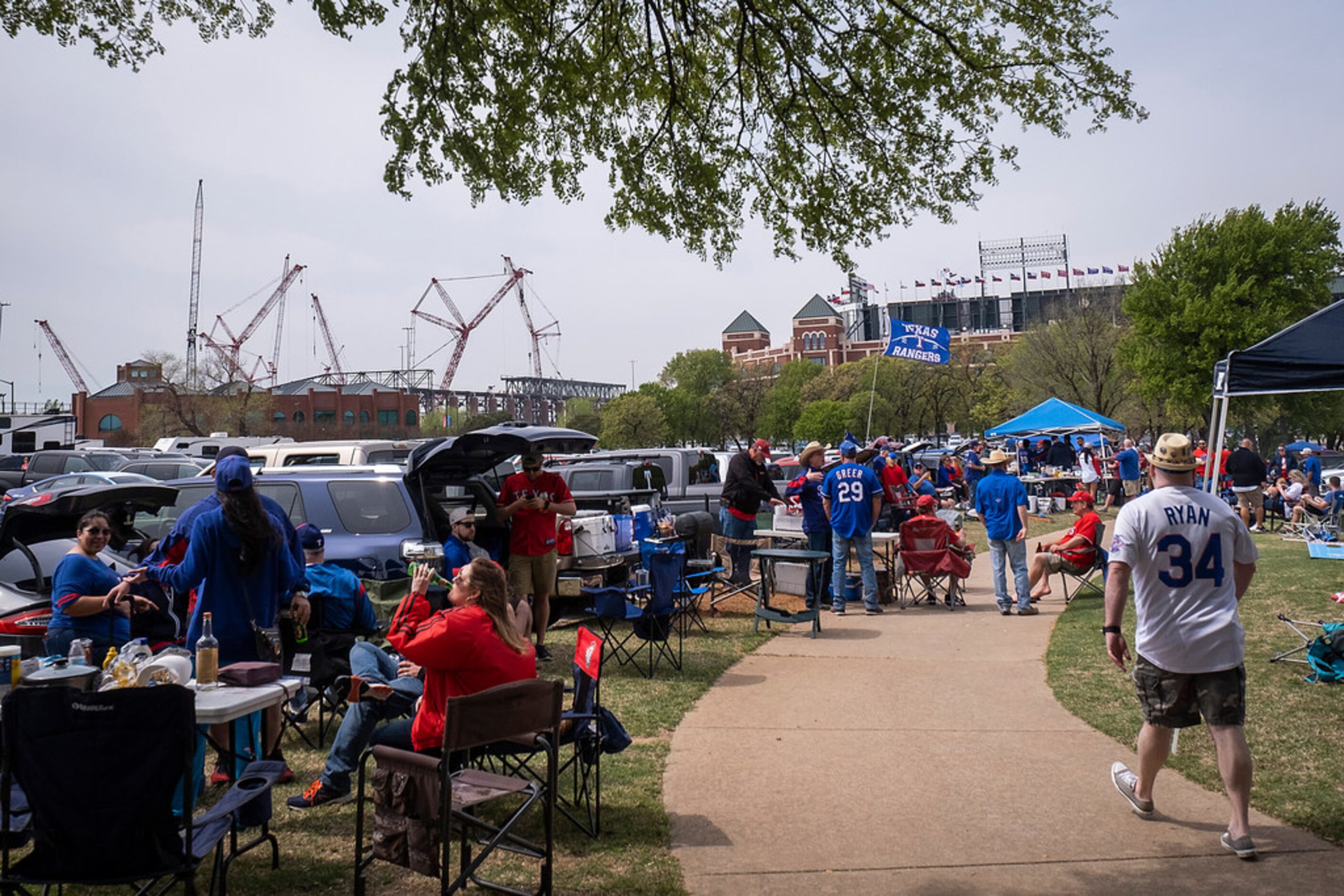 Globe Life Field rises to the left as Texas Rangers fans tailgate before the Texas Rangers...