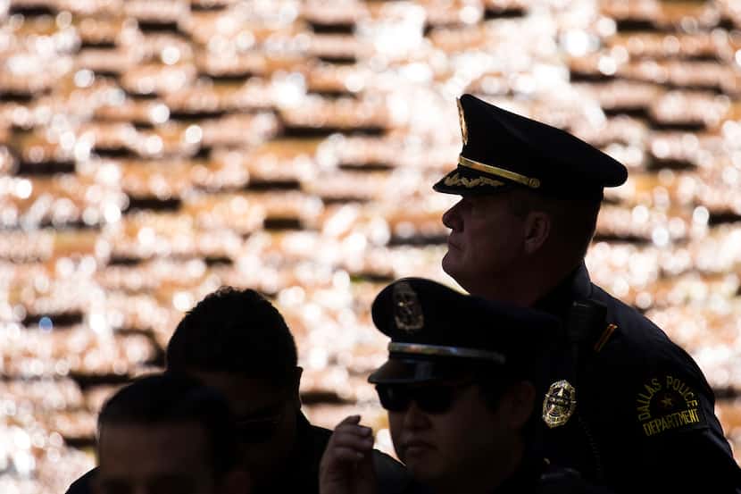 Dallas police are silhouetted against the water cascading down the Great Fountain during a...