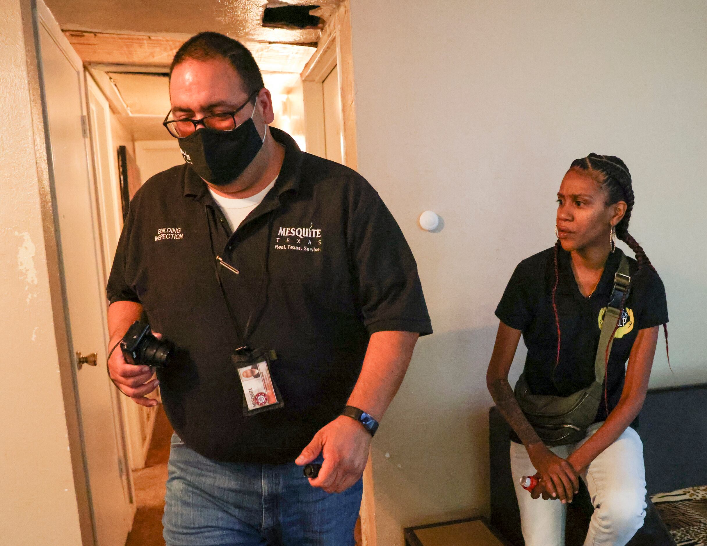 City of Mesquite Building Inspector Joe Martinez walks past current resident Brittany Jones...