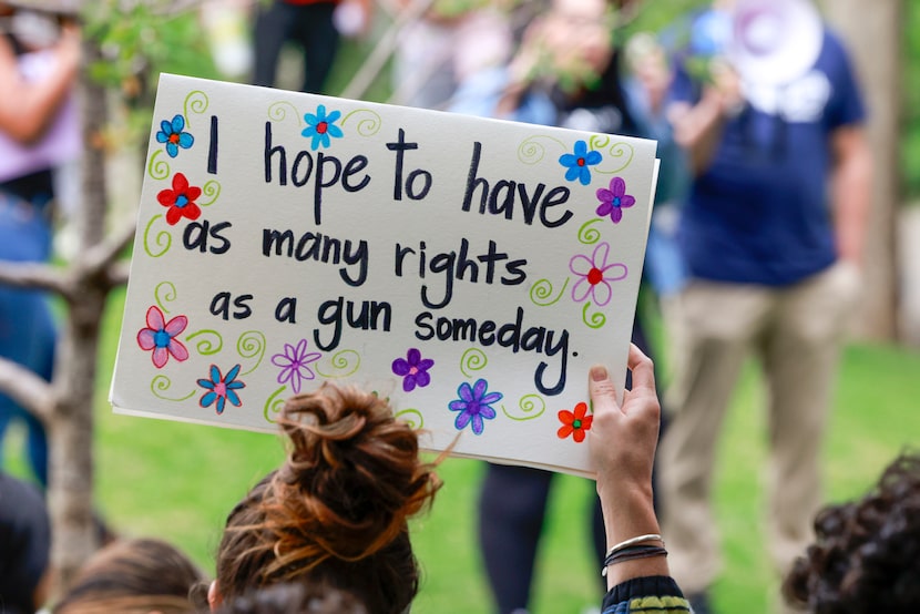 An abortion rights supporter raises a sign during a rally at the Civic Garden outside the...