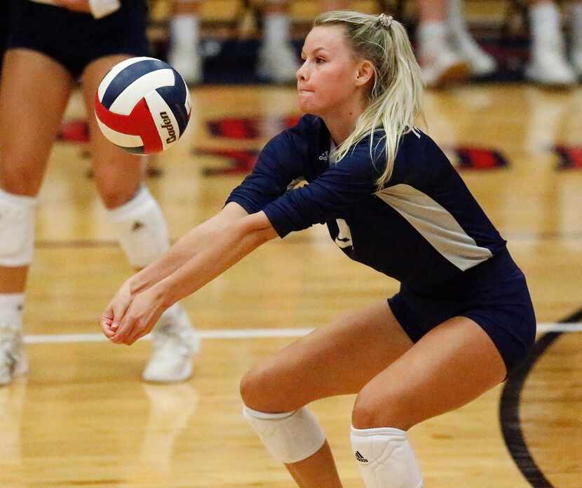 Flower Mound High School outside hitter Gabby Walker (9) receives a serve during game one as...