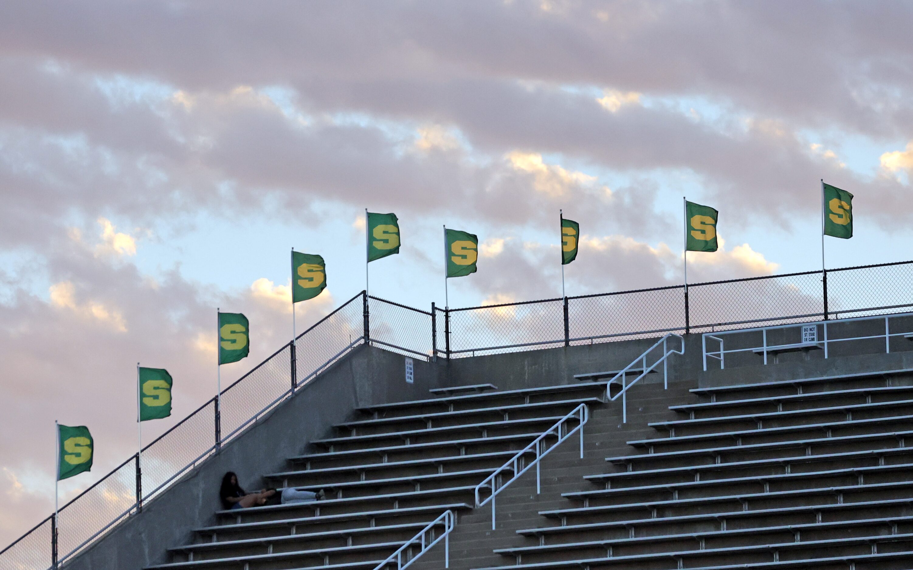 A couple communes under the cloudy twilight sky before the start of the first half of a high...