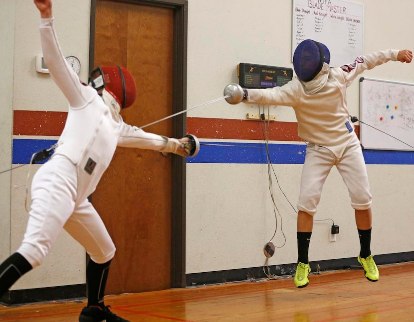 
Ariel Armoza (right), 13, of Allen lunges toward Abe Fanning, 14, of McKinney during...